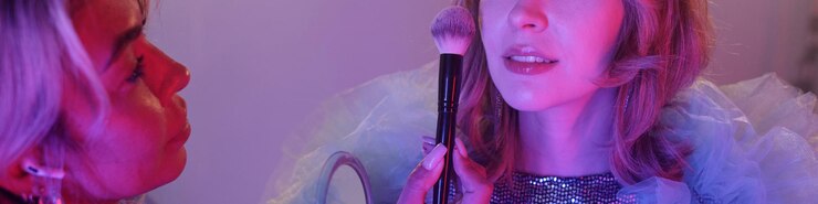 Foto artista de maquillaje aplicando rubor a una mujer detrás del escenario