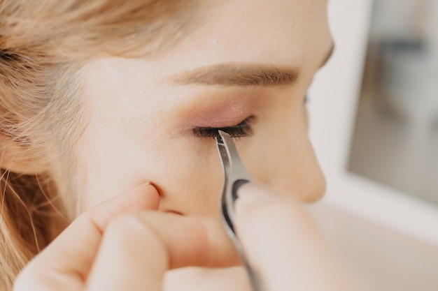 Artista de maquillaje está aplicando maquillaje en los ojos del cliente