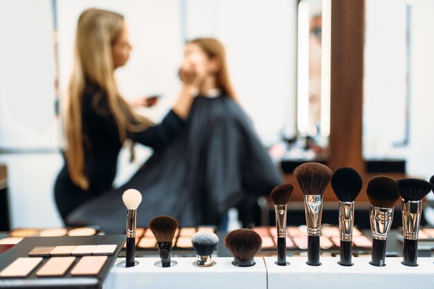 Artista de maquillaje trabaja con la cara de los clientes