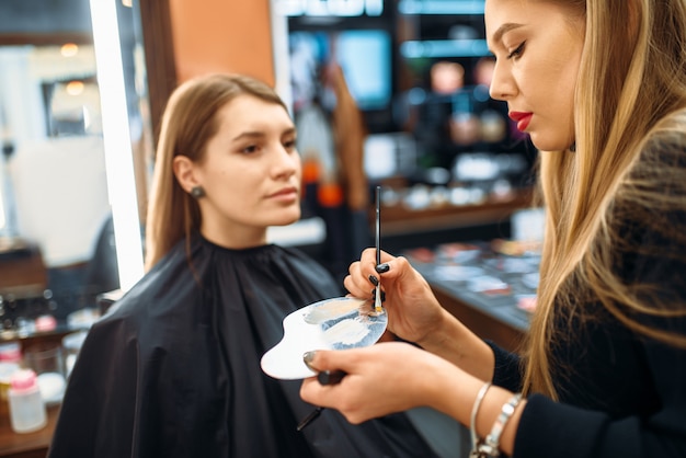 Artista de maquillaje trabaja con la piel de la cara