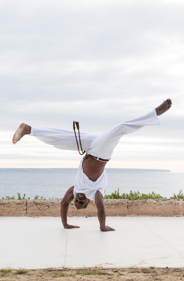 Foto artista marcial de capoeira em uma postura de mão ao ar livre expressando equilíbrio e habilidade atlética