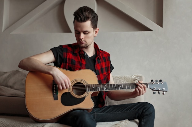 Artista masculino joven tocando la guitarra