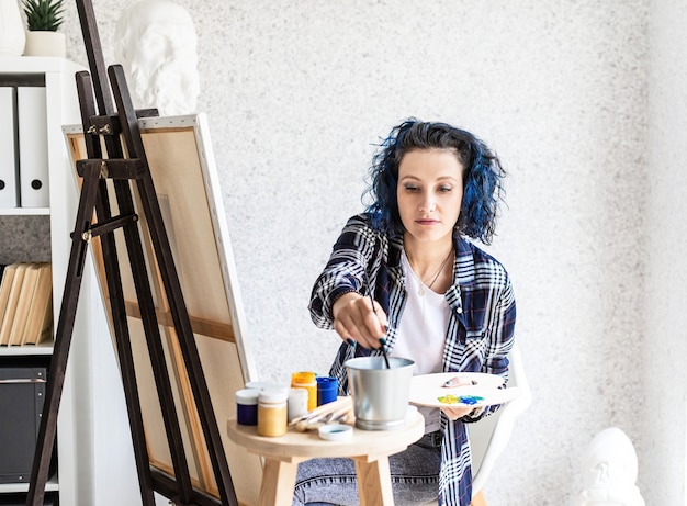 Foto artista mujer creativa pintando un cuadro trabajando en su estudio