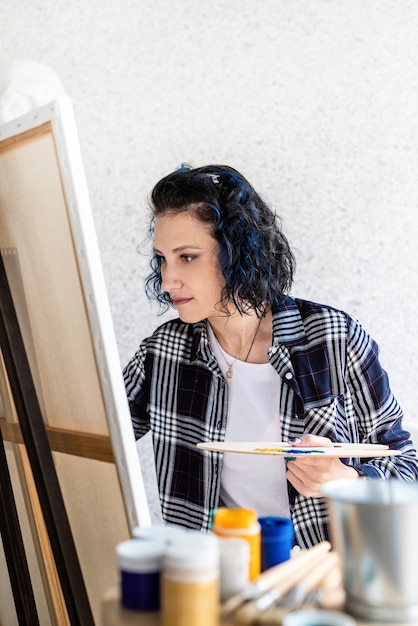 Foto artista mujer creativa pintando un cuadro trabajando en su estudio