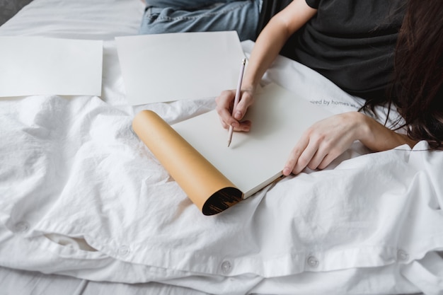 Artista mujer dibuja en un cuaderno de bocetos en casa