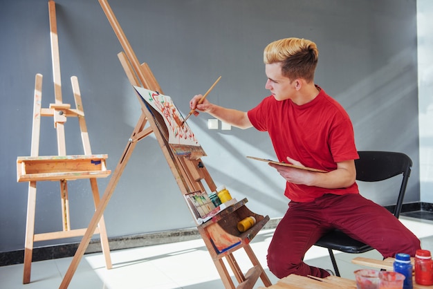 Artista pintando un cuadro en un estudio