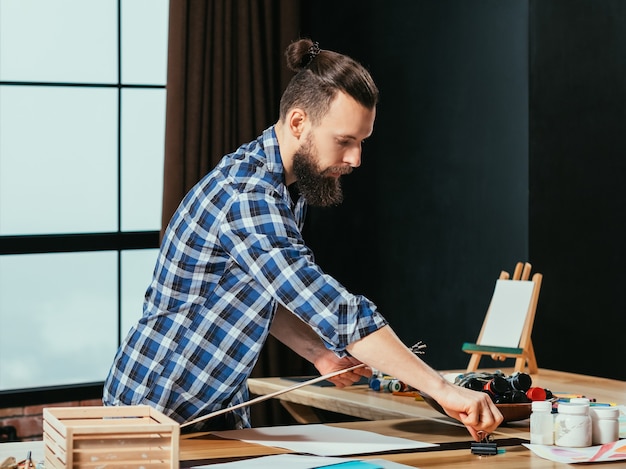 Artista pintando en el espacio de trabajo de su estudio.