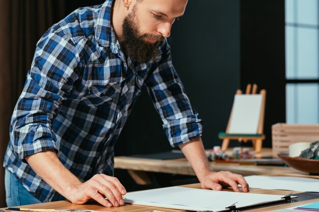 Artista pintando en el espacio de trabajo de su estudio.