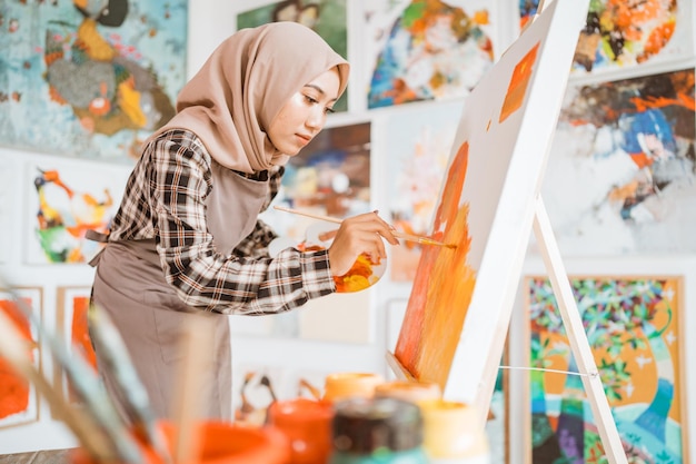 Artista pintora musulmana pintando sobre lienzo