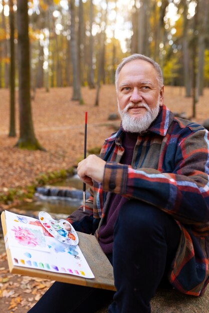 Foto artista de pintura de acuarela al aire libre en el bosque