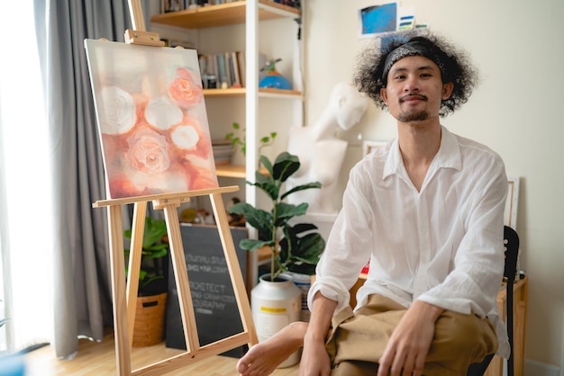 Artista de pintura joven asiático masculino que trabaja en el estudio, estilo de vida de la afición del arte en casa