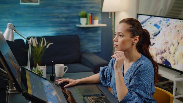 Artista de retoque editando imágenes en el estudio de fotografía. Mujer fotógrafa que trabaja con tableta gráfica y lápiz óptico para trabajos de retoque en el monitor de pantalla táctil. Editor con equipo digital