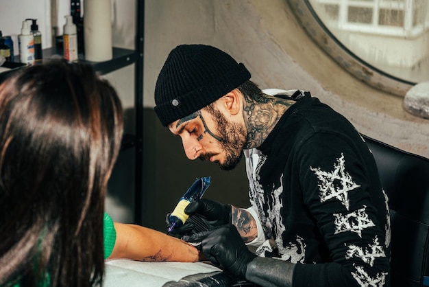 Foto un artista del tatuaje hace un tatuaje en un salón.