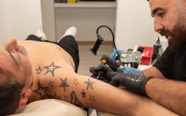 artista del tatuaje realizando un tatuaje en un cliente