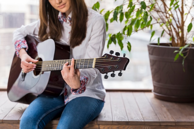 Foto artista tocando la guitarra en interiores y plantas