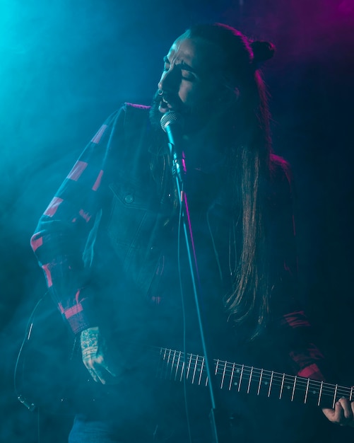 Foto artista tocando la guitarra y sintiendo la letra