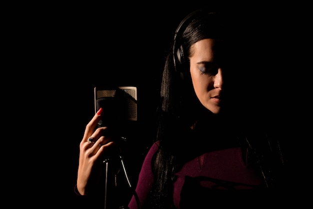 Artista vocal femenina cantando en un estudio de grabación.