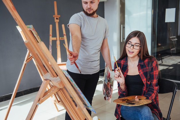 Artistas creativos pintando una imagen colorida sobre lienzo con pinturas al óleo