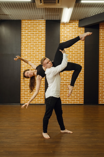 Artistas de danza contemporánea, formación de pareja en estudio. Bailarines masculinos y femeninos en entrenamiento en clase, baile moderno, ejercicio de estiramiento