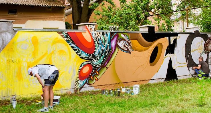 Foto artistas de rua pintando graffiti na parede em um parque