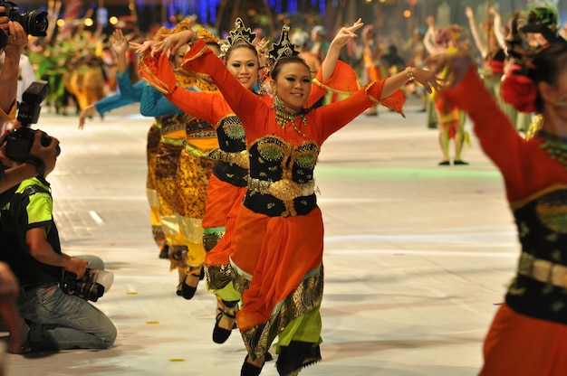 Artistas sonrientes realizando bailes tradicionales durante el carnaval.