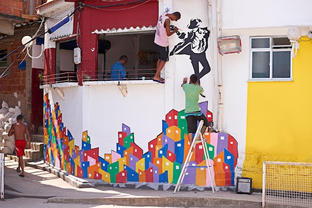 Artistas urbanos Foto de dois jovens grafiteiros pintando um desenho em uma parede