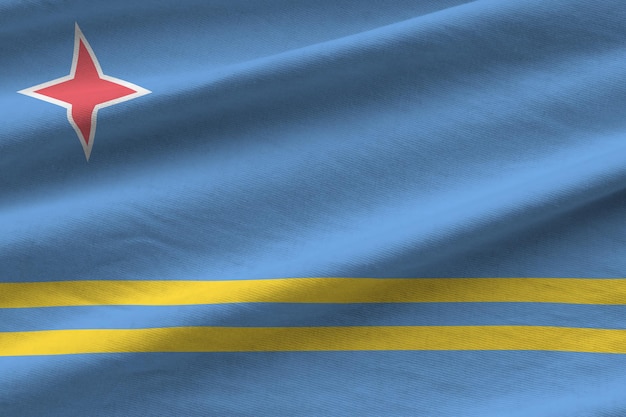 Aruba-Flagge mit großen Falten, die in der Nähe unter dem Studiolicht im Innenbereich winken Die offiziellen Symbole und Farben im Banner