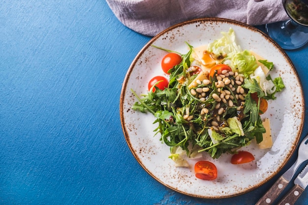 Arugula gesunder Salat mit Pinienkernen Tomaten und Käse Draufsicht Kopieren Sie Platz