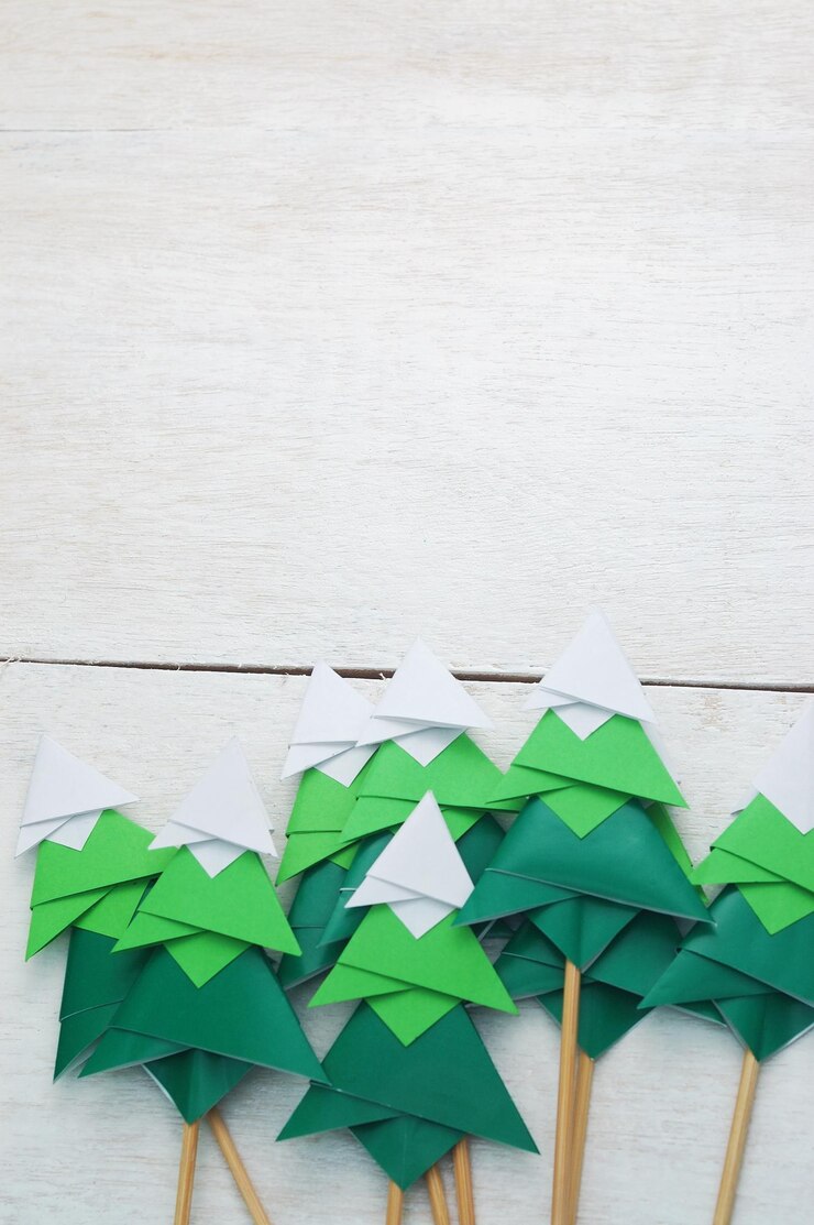 Foto árvore de natal artesanal de papel origami em fundo branco de madeira