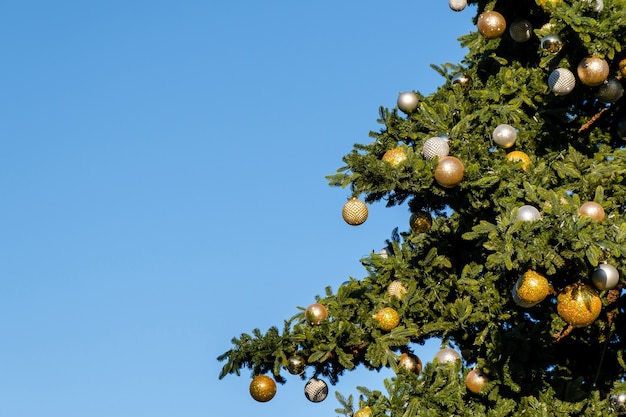 Árvore de natal artificial ao ar livre em um céu azul em um dia ensolarado de inverno.