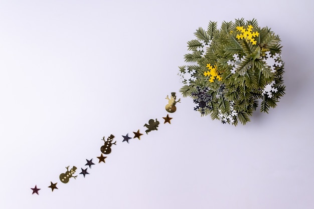 Árvore de Natal artificial e confetes em um fundo branco