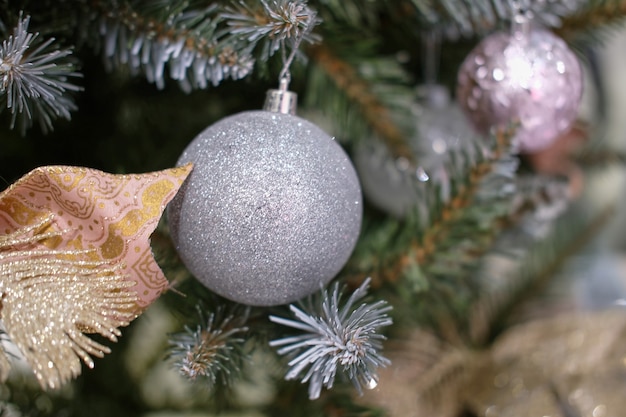 Foto Árvore de natal, bolas, enfeites com brinquedos decorativos, laços e fitas com foco seletivo