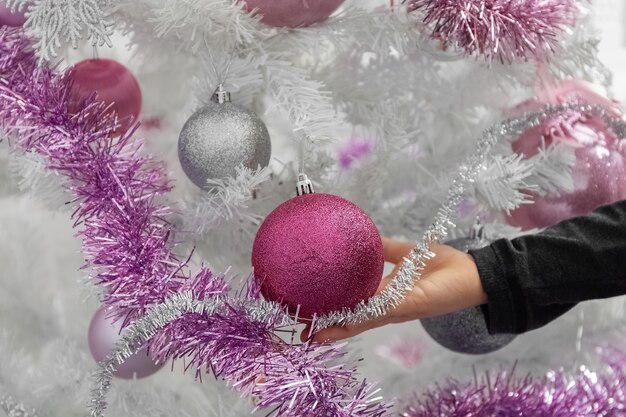 Árvore de Natal branco Mão de criança tocando bolas na árvore de Natal.