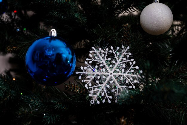 Árvore de Natal com bolas coloridas e caixas de presentes sobre parede de tijolos brancos com bolas azuis e brancas