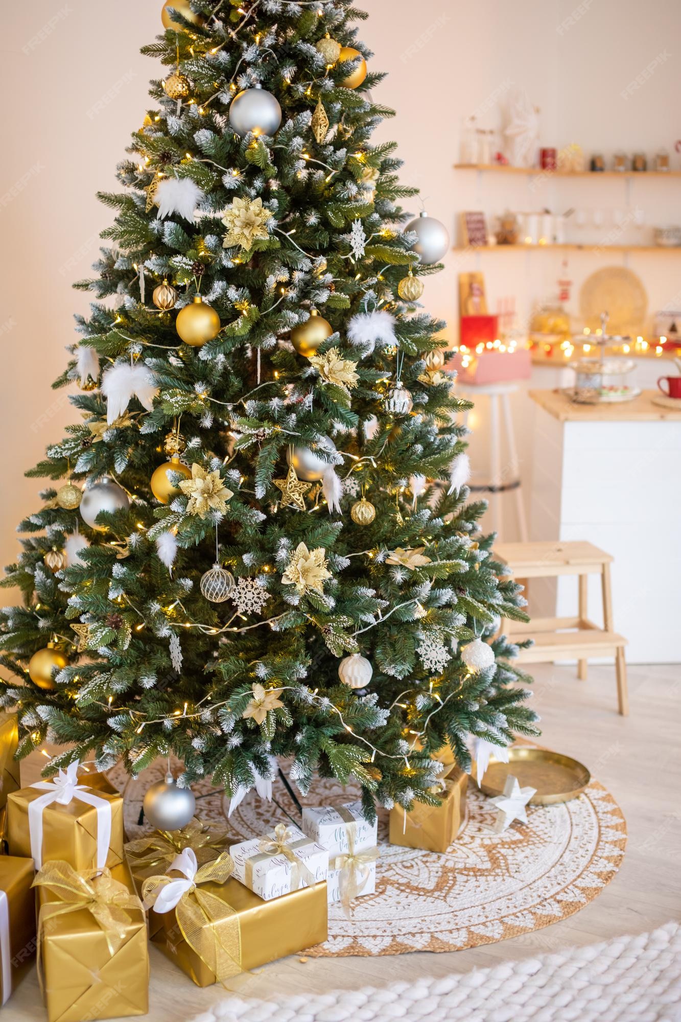 Árvore de natal com neve branca com decoração de presentes no interior da  casa de ano novo