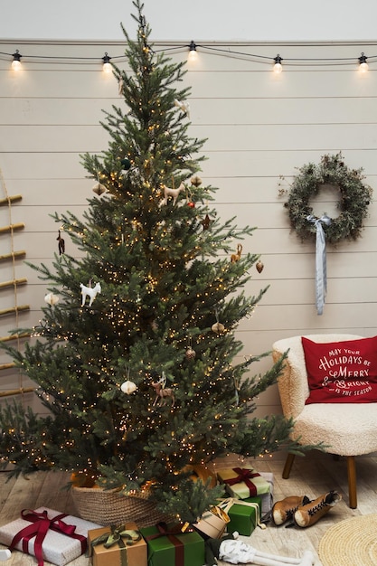 Árvore de natal com presentes vermelhos no quarto branco natal