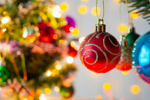 Árvore de natal decorada com bola vermelha em fundo de galhos de pinheiro