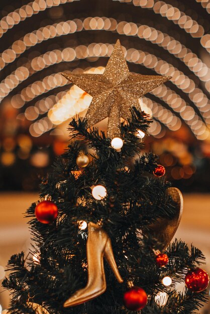 Árvore de Natal decorada com estrela dourada e sapato feminino de salto alto com estatueta de brinquedo de Natal