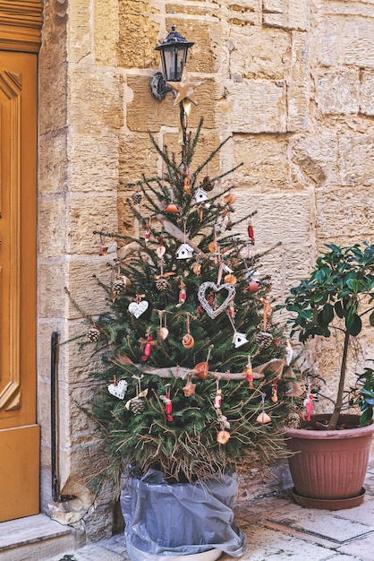 Árvore de natal decorada com guirlanda tecida em forma de coração e outros enfeites artesanais de natal sem desperdício