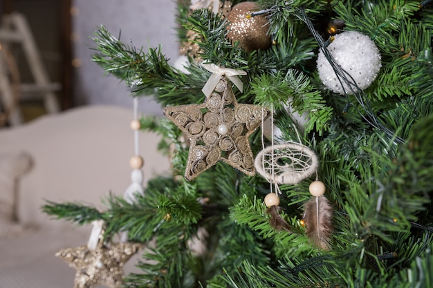 Árvore de Natal decorada ouro com ornamento de retalhos golder, corações estrelas para o ano novo na sala de estar. Fundo de férias de Natal e ano novo. Estilo escandinavo no interior. Ornamentos de Natal e