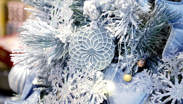 Árvore de natal decorativa coberta de neve decorada com brinquedos decorativos de árvore de natal, corações cinzentos de tecido, tous de árvores de natal de vidro, flocos de neve, decorações. fundo de ano novo de inverno de natal.