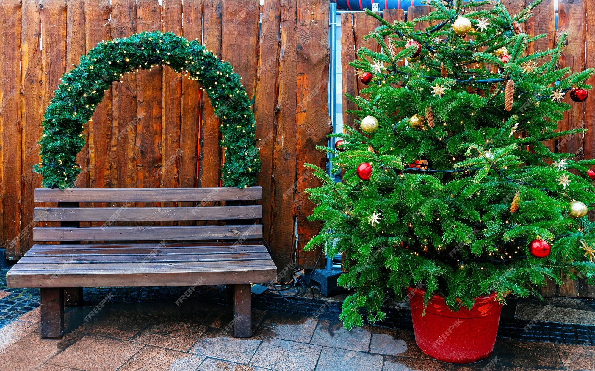 Árvore de natal e banco no mercado na igreja memorial kaiser wilhelm em berlim de inverno, alemanha. decoração da feira do advento e barracas com artigos de artesanato no bazar. | Foto Árvore de natal e banco no mercado na igreja memorial kaiser wilhelm em berlim de inverno, alemanha. decoração da feira do advento e barracas com artigos de artesanato no bazar. | Foto