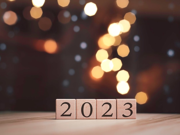 Foto Árvore de natal e bolas de caixa de presente bokeh guirlandas no bloco de cubo de fundo desfocado para conter o propósito de fazer negócios superando desenvolvendo ideias para o ano novo 2023x9