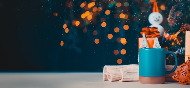 Árvore de natal e caixa de presente na caneca com bokeh de fundo claro festival