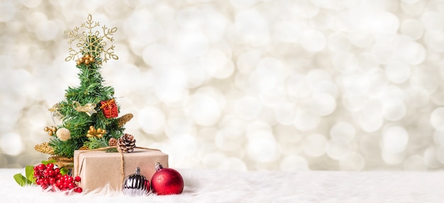 Árvore de natal e caixa de presente na luz de borrão bokeh