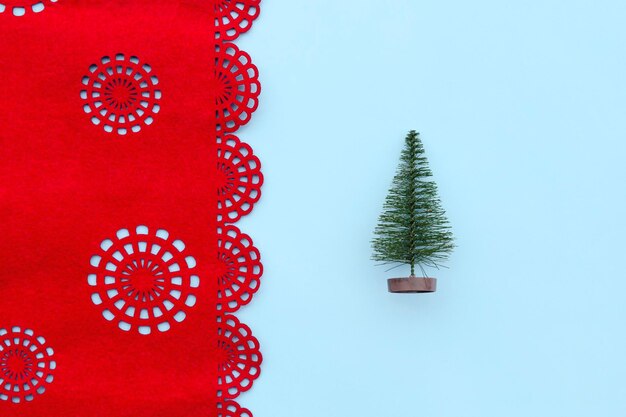 Foto Árvore de natal em fundo azul e vermelho com flocos de neve em natal decorativo de estilo minimalista