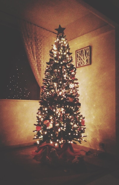 Foto Árvore de natal iluminada brilhando em casa