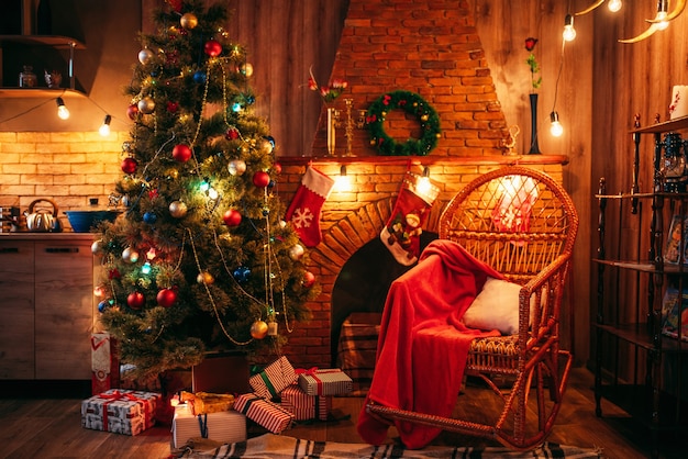 Árvore de natal na sala com decoração de feriado, ninguém. celebração de natal, lareira, meias vermelhas para presentes, guirlandas