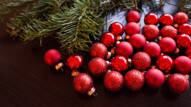 Arvores de abeto e bolas vermelhas de natal em fundo escuro