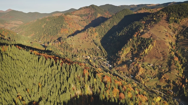 Árvores de outono sol no topo das montanhas ninguém paisagem da natureza na estrada rural em casas de campo em